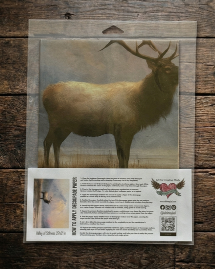 Packaged decoupage paper featuring a brown Stag standing in a grassy field, shown on a rustic dark wood background. The package includes an instruction sheet